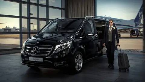 Chauffeur and Mercedes van waiting for passengers at Stansted
