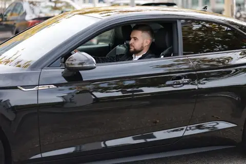 Driver at the wheel of a black car