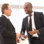Two men in dark suits talking